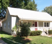 Siding home with red front door white trim windows front porch with white railing and white columns
