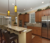 Kitchen with brown cabinets brown granite countertops brown tile backsplash stainless steel appliances light brown walls