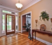 Front entryway with brown walls white trim wood floors wood paned glass door