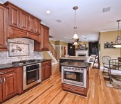 Kitchen brown cabinets stainless steel appliance wood floors black granite countertops