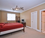 Bedroom with brown walls double ceiling fan carpet flooring window and white door