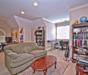 Room with light brown walls carpet floors sofa and desk areas