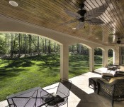 Back porch with tile flooring paneled wood ceiling ceiling fan with leaf blades green grass backyard