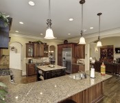 Kitchen with light brown walls dark wood floors and cabinets stainless steel appliances brown granite countertops brown tile backsplash