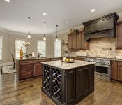 Kitchen with light brown walls dark wood floors and cabinets stainless steel appliances brown granite countertops brown tile backsplash