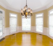 Dining room with large windows yellow walls vaulted ceiling with chandelier wood floors