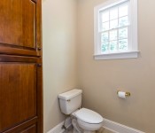Bathroom with yellow walls white toilet window over toilet dark wood cabinets