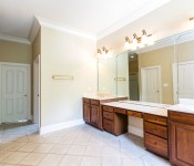 Bathroom with tile flooring yellow walls white baseboards dark brown wood cabinets white countertops
