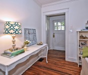 Living room with white walls white molding wood floors dark brown ceiling fan white sofa white front door