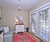 Room with tile flooring light brown walls white baseboards large window and door to backyard