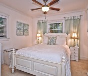 Bedroom with white walls dark wood ceiling fan white molding carpet flooring white furniture