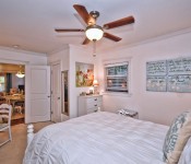 Bedroom with white walls dark wood ceiling fan white molding carpet flooring white furniture