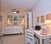 Bedroom with white walls dark wood ceiling fan white molding carpet flooring white furniture window over bed