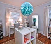 Bedroom converted into large closet with wood floors gray walls windows with white curtains built ins and bookshelves with clothes shoes and accessories blue floral chandelier