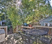 Back deck with metal table and chairs green egg grill wood floor and railing