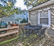 Back deck with metal table and chairs green egg grill wood floor and railing