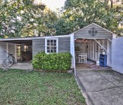 Backyard with green grass and trees hammock and open shed with eating area