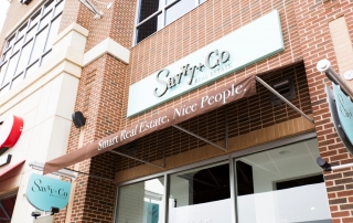 Savvy and Co Real Estate brick building with brown awning and blue sign