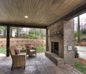 Back porch with tile flooring brown brick walls and brown brick built in fireplace wood roof sitting area chairs