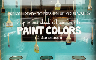 Window display hanging paintbrushes Savvy and Co branded paint cans blue wall