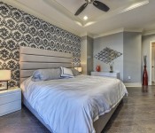 Bedroom with gray wood floors gray walls black and white wallpaper wall recessed lighting ceiling fan tray ceiling