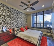 Bedroom with gray walls gray flooring window with view of uptown Charlotte skyline ceiling fan recessed lighting wall with black and white wallpaper