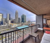 Porch with outdoor furniture wood floors metal railing view of uptown Charlotte skyline