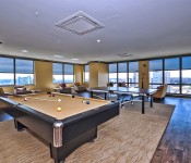 Game room with ping pong table and pool table wood floors yellow paint floor to ceiling windows view of uptown Charlotte