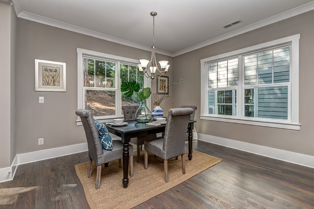 Dining room with gray walls white trim white trim windows wood floors