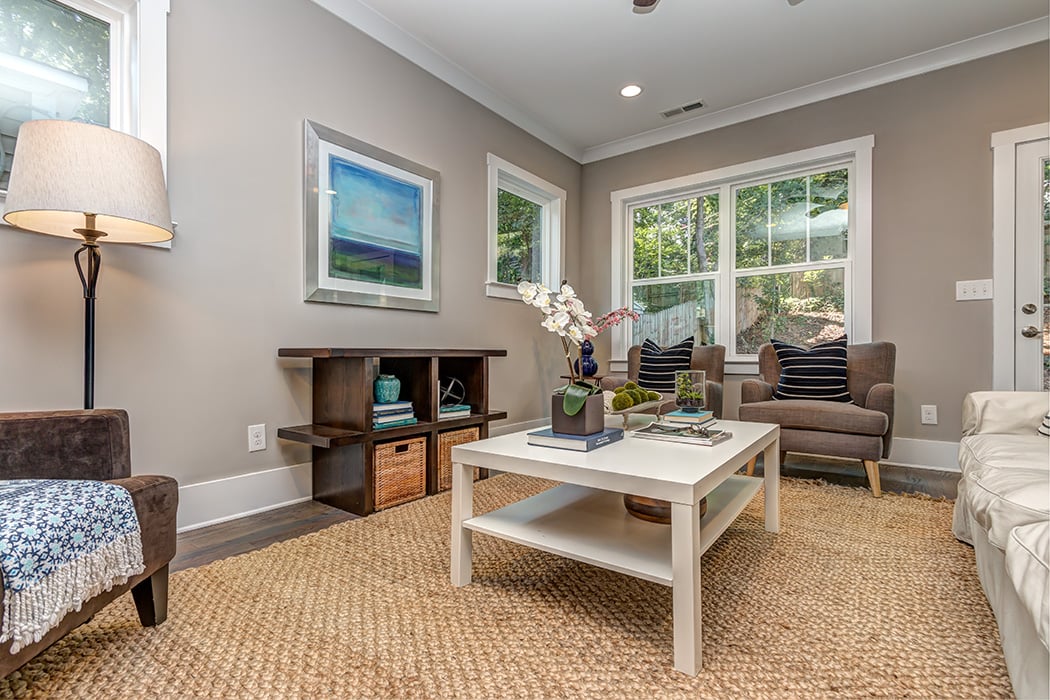 Living room with gray walls white baseboards and white trim windows wood floors recessed lighting