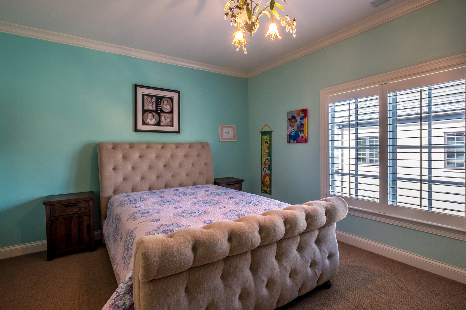 Bedroom with light blue walls brown carpet white trim white chandelier windows with built in blinds