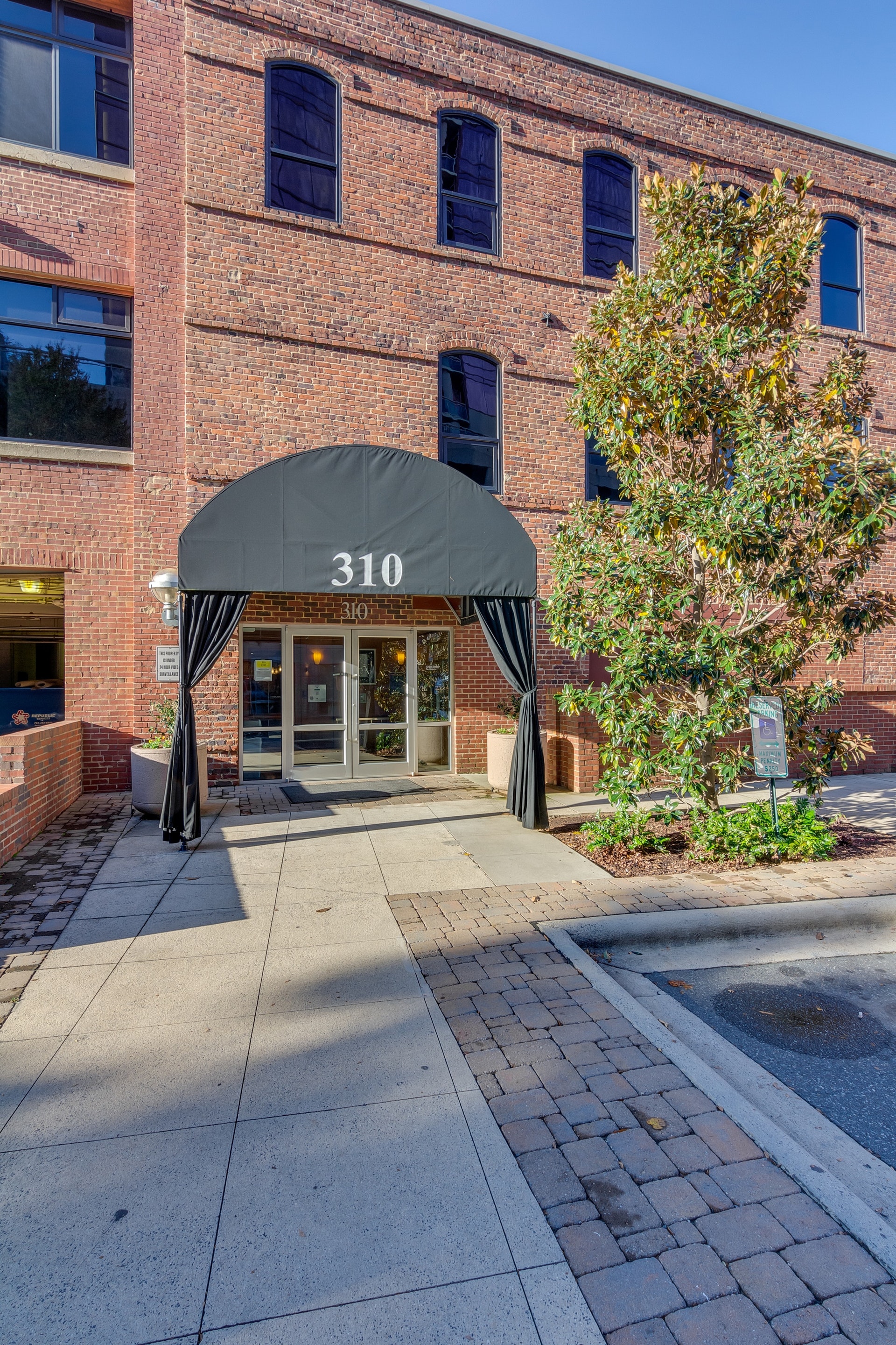 Red brick condo building with black awning with white 310 printed on it