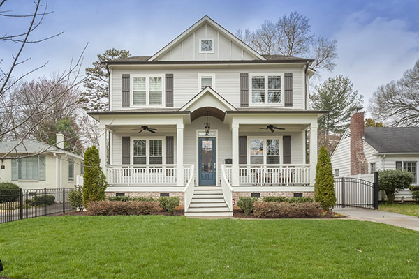 Two story home with light gray siding gray shutters large front porch with white columns and white railing two black ceiling fans on porch blue front door