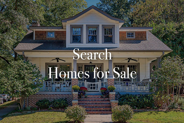 White siding home with brick porch brown shingles and gray trim with large front porch and black ceiling fans