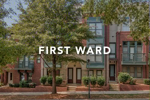 Townhome with a mix of red brick gray siding and green trim and the words First Ward typed over it in white font
