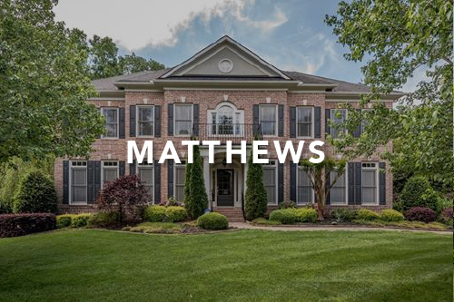 Matthews Large brown brick two story home with large windows and black shutters large green front yard with the word Matthews typed over the image