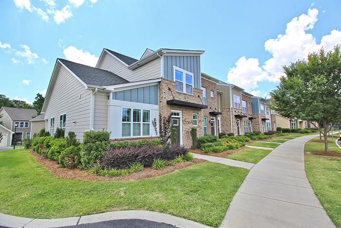 End unit townhome with landscaped front yard light brick and cream siding