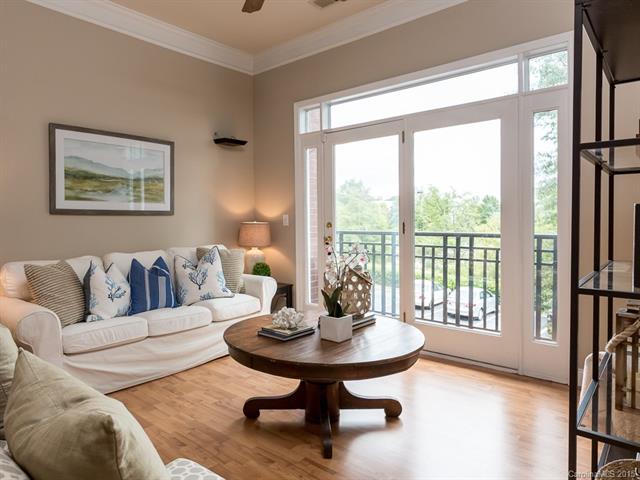 Living room with gray walls light wood floors and door leading to patio
