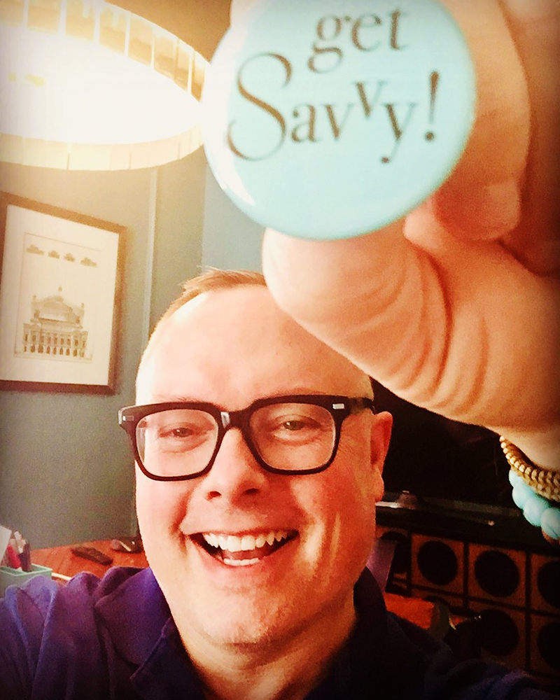 Get Savvy with Kelly King Kelly King holding up blue Get Savvy pin