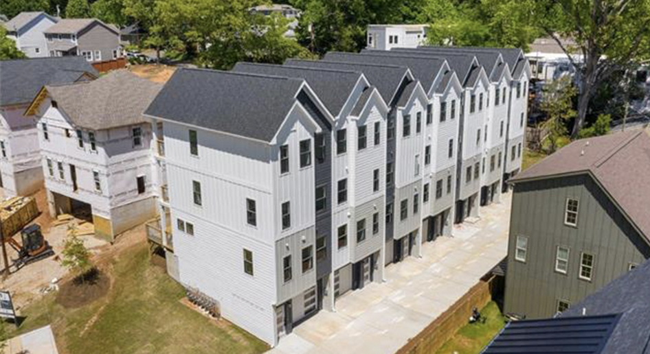 Hamorton Row Aerial shot of a row of gray and white siding four story townhomes next to homes under construction